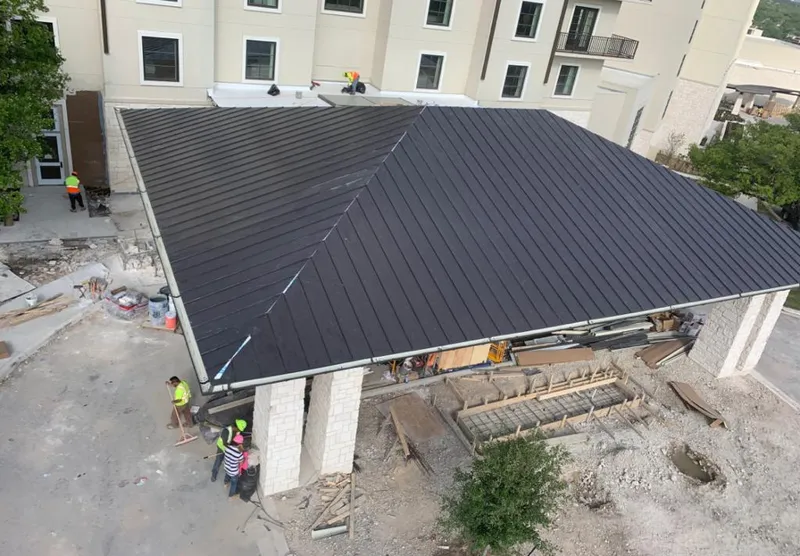 Metal roofing installation team working on a commercial building in Wilna